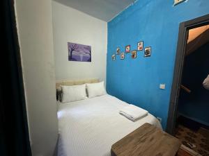 um pequeno quarto com uma cama com uma parede azul em Rooms Next 2 Museum of Innocence em Istambul