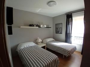 En eller flere senge i et værelse på Cómodo apartamento en A Ladeira