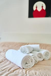 une pile de serviettes assises au-dessus d'un lit dans l'établissement Casa Rosita, à Carbonia