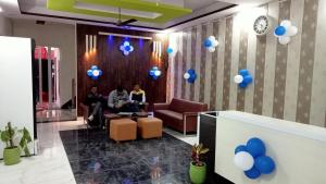 a group of people sitting in a lobby with blue balloons at OYO Hotel Bliss in Rewāri
