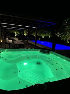 a jacuzzi tub in a backyard at night at BlueGreen Villa in Karteros