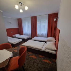 1 Schlafzimmer mit 2 Betten, einem Tisch und Stühlen in der Unterkunft Sangos Ośrodek Sportowo-Szkoleniowy in Górki Wielkie