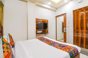 a bedroom with a bed and a television in it at FabHotel The Luxurie International in kolkata