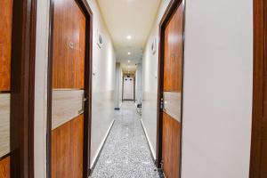 a corridor with wooden doors and a hallway with a aisle at FabHotel The Luxurie International in kolkata