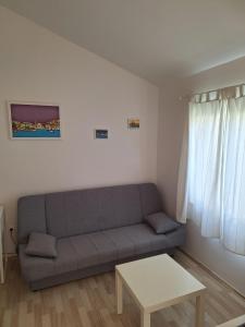 een woonkamer met een bank en een tafel bij Pension Oaza in Hvar