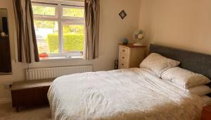 - une chambre avec un lit blanc et une fenêtre dans l'établissement Richard's Home, à Kidderminster