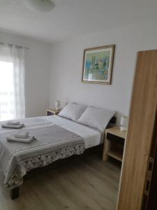 a bedroom with a bed and a picture on the wall at ApartmanA&J1111 in Kaštela