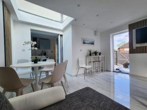 a white living room with a table and chairs at Spacious and bright one bedroom apartment in Oxford