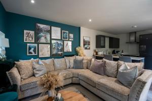 a living room with a couch and a blue wall at Spring Mount Huge Luxury Full Apartment- Harrogate Centre-Two extremely comfy Kingsize Bedrooms-Fully equipped Modern Kitchen-Cosy living room with Huge TV in Harrogate