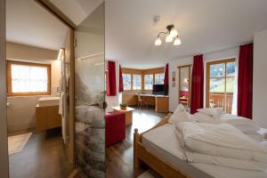 a bedroom with a large bed and a bathroom at Hotel Bergfrieden in Martello