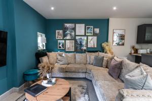a living room with a couch and a table at Spring Mount Huge Luxury Full Apartment- Harrogate Centre-Two extremely comfy Kingsize Bedrooms-Fully equipped Modern Kitchen-Cosy living room with Huge TV in Harrogate
