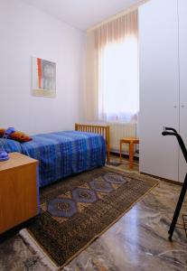 a bedroom with a bed and a rug at Le Luise in Valdobbiadene