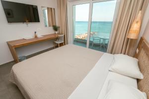 a bedroom with a bed and a view of the ocean at Sunbeam in Kardamaina