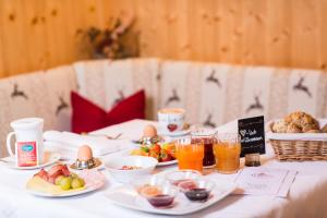 uma mesa coberta com pratos de alimentos e bebidas em Hotel Bergfrieden em Martello