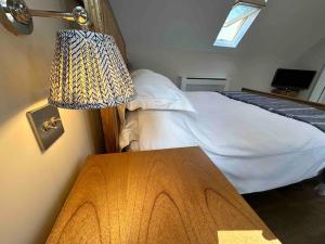 a bedroom with a bed and a table with a lamp at The Loft at the Croft - Stunning rural retreat perfect for couples & dogs in Leigh