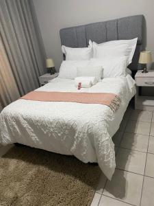a bedroom with a large bed with white sheets and pillows at Yanaz Place in Germiston