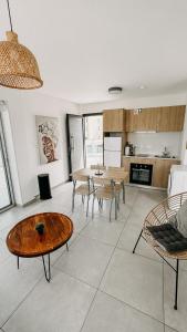 a living room with a table and chairs and a kitchen at WAKE UP BY THE SEA FLATS in Protaras