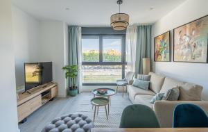 a living room with a couch and a tv at Stay U-nique Apartments Martiricos in Málaga