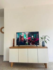 a television on a white cabinet in a living room at Appartement meublé en plein centre-ville de Diego Suarez in Diego Suarez