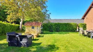 a backyard with a dog house and a table and chairs at Quiet and cozy apartment close to nature in villa. in Tilst +22 photos