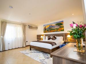 een slaapkamer met een bed en een vaas met bloemen bij LIGHT VILLAS in Nairobi