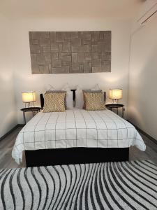 a bedroom with a large white bed with two lamps at Dolce vita Prémium in Budapest
