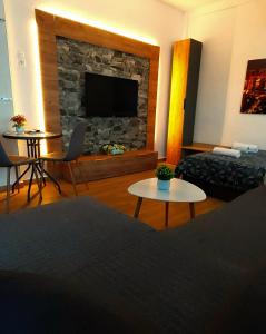 uma sala de estar com uma lareira de pedra e uma televisão em ALEXANDER Golden View Serres em Serres