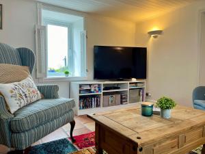 a living room with a tv and a couch and a coffee table at Sweet Lamb Farmhouse in New Ross