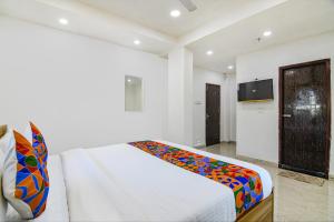 1 dormitorio con 1 cama con una manta colorida en FabHotel Grand Hazra Inn en Calcuta