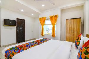 um quarto com uma cama grande e uma janela em FabHotel Grand Hazra Inn em Calcutá