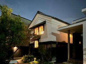 松山市にあるグループに最適The Bath & Bed Dogo 築110年の蔵をリノベした源泉掛け流し一棟貸しの温泉宿の灯り付白い家