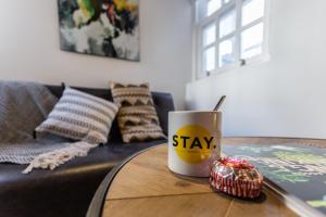 una mesa de café con una taza que diga que te quedes en ella en Stay Central Hotel, en Edimburgo