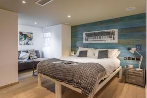 Un dormitorio con una cama con una pared de acento azul en Stay Central Hotel, en Edimburgo