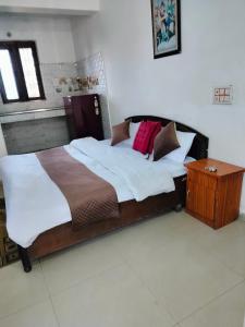 1 dormitorio con 1 cama grande con almohadas y mesa en 0 point home stay Mussoorie, en Mussoorie