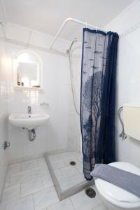 uma casa de banho com um lavatório e uma cortina de chuveiro em Kontogoni Rooms em Elafonisos