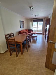 a dining room and living room with a table and chairs at Apartamento playa Carrabuxeira (Sanxenxo) in Sanxenxo