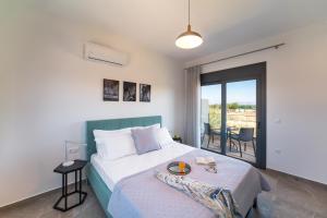 a bedroom with a bed and a balcony with a table at Lotus Luxury Apartments in Kremasti