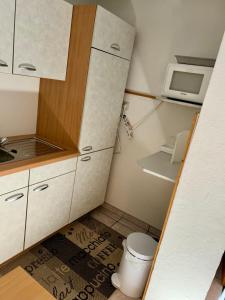 a small kitchen with a toilet and a microwave at Ferienwohnung Apperle in Götzens