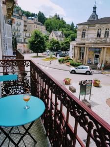 una mesa azul en un balcón con una calle en Tradition Plombières en Plombières-les-Bains