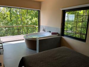 a large bathroom with a tub and a large window at Chado Belgrade in Belgrade