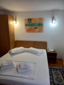 een wit bed met twee handdoeken erop bij Casa Tulceanu in Sulina +2 foto's