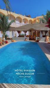 a resort with a large blue swimming pool at Hôtel évasion pêche djilor île sine saloum in Fatick