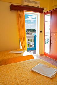 Habitación con 2 camas y vistas a un balcón. en Olympion Beach Hotel, en Gerakini