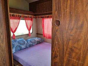 a small bed in an rv with a window at Plav Lake Camping in Plav
