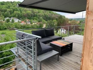 a patio with a couch and a table on a deck at Tiny Häuser im Kupfertal in Forchtenberg