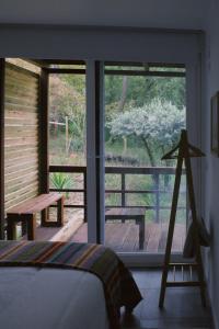 a bedroom with a bed and a view of a porch at Casa Oliva - Casa do Lago in Porto de Mós