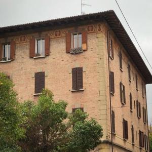 a large brick building with windows and shutters at Brand New !!! Ancient BOLOGNA Centrale LIBERTY Style Completely RENOVATED 2025 in Bologna