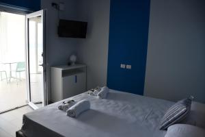 a blue bedroom with a bed with towels on it at Terrazze Naos in San Leone