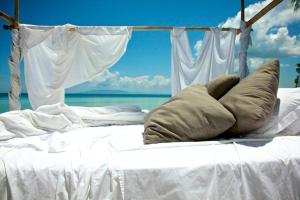 ein weißes Bett mit einem Kissen darüber in der Unterkunft Ananyana Leisure Beach Resort in Panglao