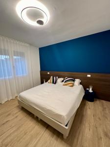 考特達蒂諾的住宿－LA ROSA DEL SILE，一间卧室设有一张蓝色墙壁的大床